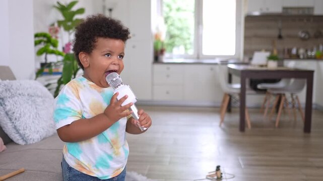 Toddler enthusiastically singing into a toy microphone