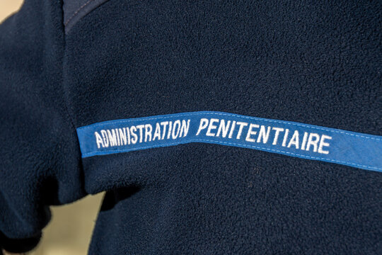 Marquage "Administration P&eacute;nitentiaire" &eacute;crit &agrave; l'avant de l'uniforme d'un personnel. L'Administration P&eacute;nitentiaire est un service en charge des prisons et de l'ex&eacute;cution des peines en France