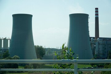 Obraz premium Two Massive Concrete Cooling Towers and a Chimney of Power Plant
