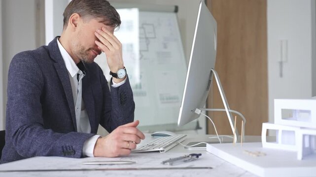 Architect working on computer creating building design, drafting construction plans, modeling house layout. Business and architecture concept