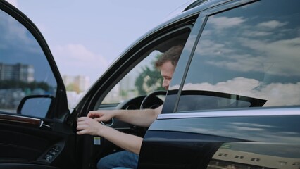 Young man helping little boy getting out the car. Slow motion