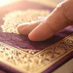 Close up of a Human Finger Gently Touching an Ornate Islamic Book with Golden Decorations and Warm Sunlight
