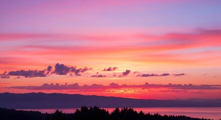 Fototapeta premium Serene landscape with vibrant sunset over mountains and water body, viewed from a distant vantage point, capturing the beauty of nature and sky