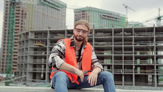 Tired builder getting rid of protective helmet on building site