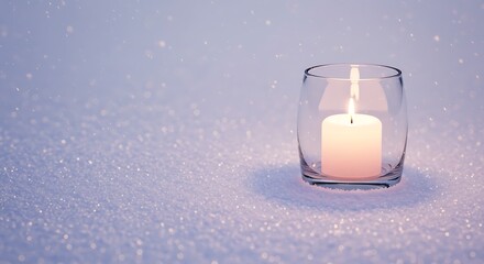 Lit candle in glass holder on snowy surface with soft ambient lighting