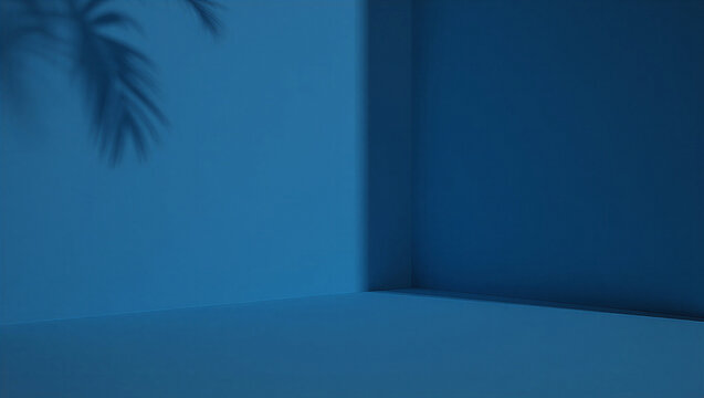 Moody blue studio with subtle, soft shadow of a tropical leaf