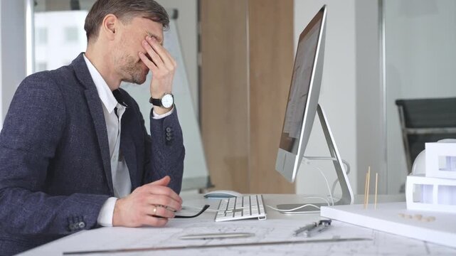 Architect working on computer creating building design, drafting construction plans, modeling house layout. Business and architecture concept