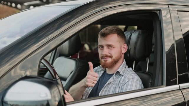 Male driver sitting in the car and showing thumbs up. Slow motion