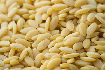 closeup macro raw risoni or rice shape pasta food background texture