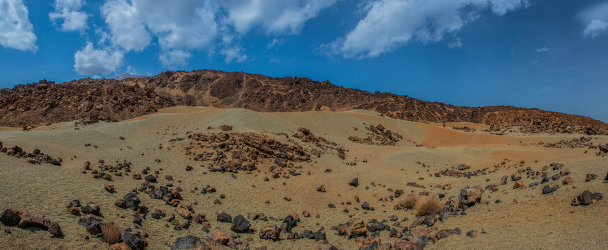 Tenerife, Canary Islands, Spain: red mountains, rock formations and rainbow sand dunes hiking in the Teide National Park with Mount Teide (Pico del Teide) on the background, spectacular landscape