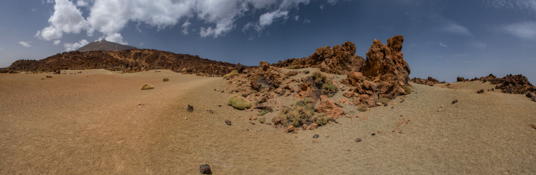 Tenerife, Canary Islands, Spain: red mountains, rock formations and rainbow sand dunes hiking in the Teide National Park with Mount Teide (Pico del Teide) on the background, spectacular landscape