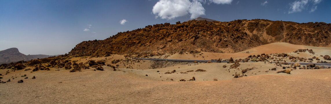 Tenerife, Canary Islands, Spain: red mountains, rock formations and rainbow sand dunes hiking in the Teide National Park with Mount Teide (Pico del Teide) on the background, spectacular landscape