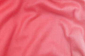 A bright pink fabric with soft folds. A soft knit surface with a distinctive weave.
