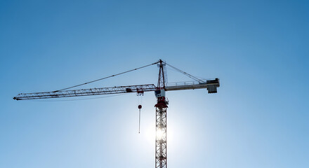 Construction crane silhouette against clear blue sky