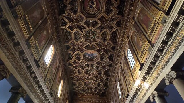Slow motion upward view of the golden coffered ceiling in Santa Maria in Trastevere, Rome