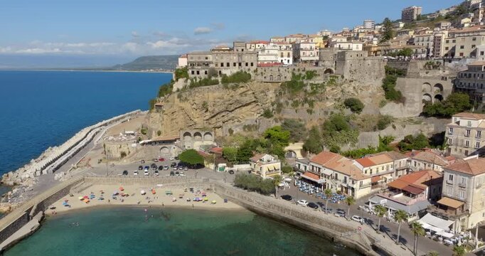 Aerial panoramic view of Pizzo Calabro, Italy, showing the historic town perched on a tuff cliff overlooking the Mediterranean Sea. In foreground there are the Aragonese Castle and the Marina district