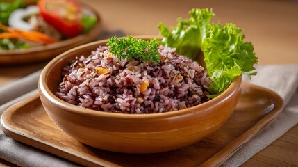 A rustic wooden bowl filled with purple mixed rice garnished with fresh herbs and served with a side salad