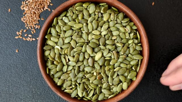 Shelled pumpkin seed kernels, salted, roasted, or raw, are a healthy ingredient. Pumpkin seeds as a food background for your design