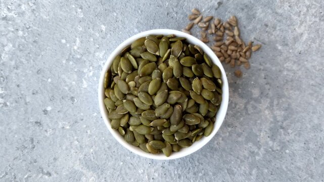 Shelled pumpkin seed kernels, salted, roasted, or raw, are a healthy ingredient. Pumpkin seeds as a food background for your design