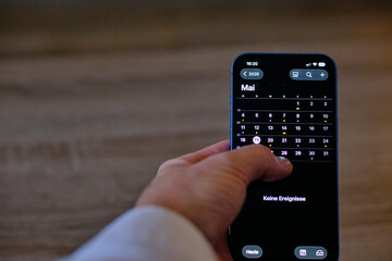 Handy Iphone in der Hand mit Kalender 