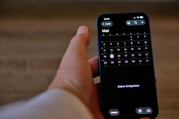 Handy Iphone in der Hand mit Kalender 