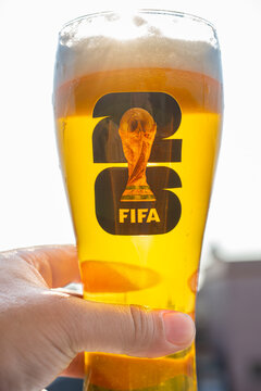 ZHONGSHAN China-October 11 2025: man holding a cup of beer with the 2026 World Cup logo at vertical composition.