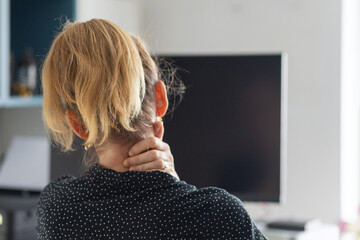 woman suffering from neck pain at her desk