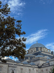 Obraz premium A vertical shot featuring the majestic stone architecture of a mosque, showcasing multiple grey lead-covered domes and intricate masonry. The image captures the upper section of the religious structur