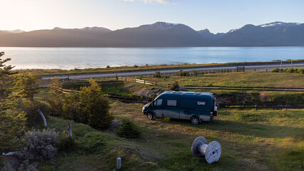 Fototapeta premium Van Life Adventure: Drone Shot of Camper Van by Snowy Mountains and Sea