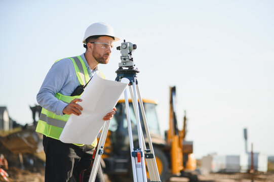 Surveyor engineer supervising construction site with leveling equipment