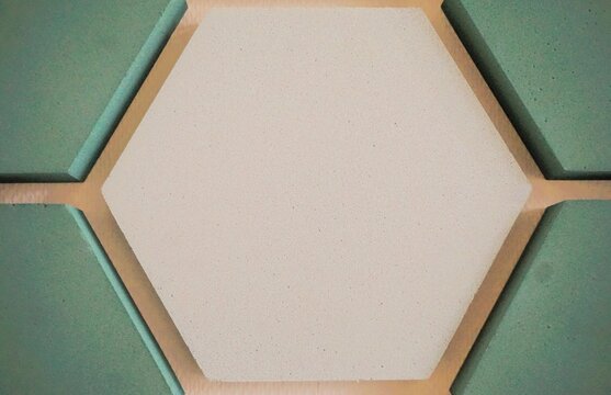 Wanddekoration mit beigem 6-eck mit goldfarbenem Rahmen als Hintergrund