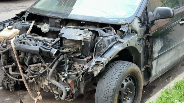 Disassembled car engine, a removed bumper after an accident, shows exposed engine parts and various internal mechanical parts awaiting repair and diagnosis. The front view of the car is disassembled.