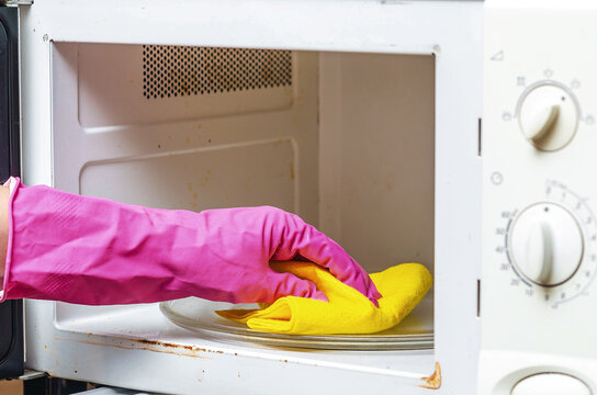 Cleaning old dirty microwave from grease, soot. Microwave oven switches. Kitchen cleaning concept.