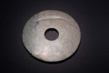 Neolithic jade bi disc artifact displayed in close-up under museum lighting © zhu difeng