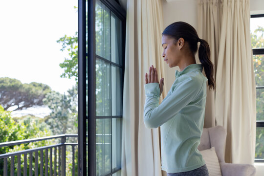Sliding glass door is letting soft daylight into living room near balcony and trees