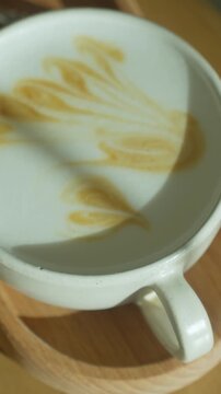 Golden Leaf Coffee. Ceramic Mug With Detailed Latte Art. Foamy Coffee In Cup Featuring Golden Leaf Design On Top. Sunkissed Latte With Intricate Leaf Shape Embellishment On Smooth Foam Surface