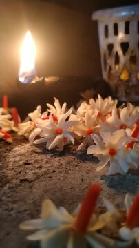 Traditional Oil Lamp with Night Jasmine Flowers Burning in Dark Spiritual Background