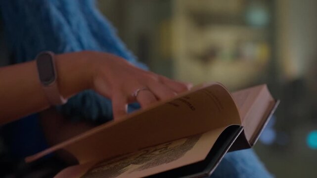 Closeup Of Girl Reading. Hand Gestures And Soft Lighting. Cozy Scene With Fingers Flipping Pages Under Gentle Light. Intimate Snapshot Of Girl Engrossed In Book With Tactile Details