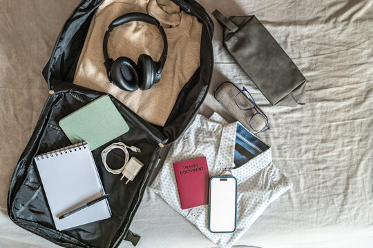 Modern travel flat lay with open backpack