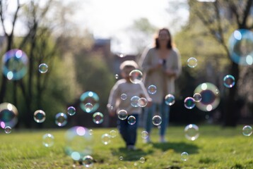 Soap Bubbles Floating In Park With Mother And Child Behind