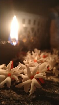 Traditional Oil Lamp with Night Jasmine Flowers Burning in Dark Spiritual Background	