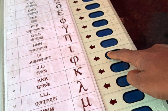 Person presses a button on an Electronic Voting Machine (EVM)