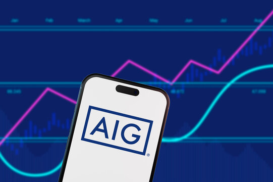 Brooklyn.New York.USA-02.13.2026:AIG logo on a smartphone screen over a blue financial stock market chart background