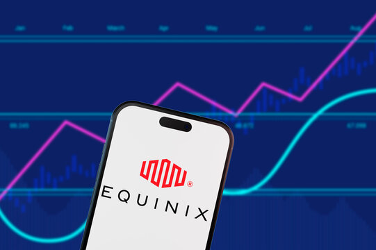 Brooklyn.New York.USA-02.13.2026:Equinix logo on a smartphone screen over a blue financial stock market chart background.