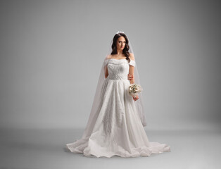 Fototapeta premium Full length portrait of a bride wearing off shoulder bridal gown