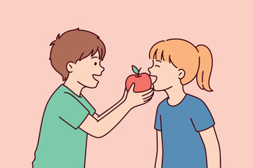 Fototapeta premium Cheerful boy offers a bite of a ripe apple to a young girl. They are happy children sharing a healthy snack, representing kindness, sibling bonding, and a positive start to nutrition.