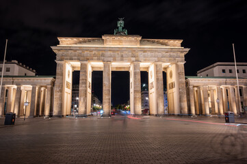 Obraz premium Berlin, germany, august 13, 2023. Brandenburg gate in glowing against the night sky, neoclassical monument and symbol of german unity and history, empty street