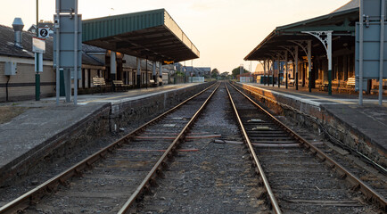 Obraz premium Barmouth ,Wales, 14 june 2023 Peaceful Train Platform At Barmouth Station With Stop Sign, Shelter And Railway Tracks