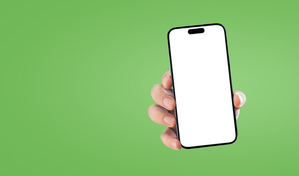 Hand holding smartphone mockup with blank screen over solid green background concept of modern technology