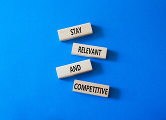 Relevant and Competitive symbol. Concept words Stay Relevant and Competitive on wooden blocks. Beautiful bright blue background. Business and Stay Relevant and Competitive concept. Copy space.